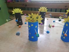 some paper cups are sitting on a table with pins and magnets attached to them