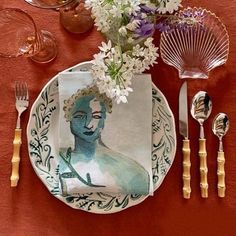 a table setting with plates, silverware and flowers