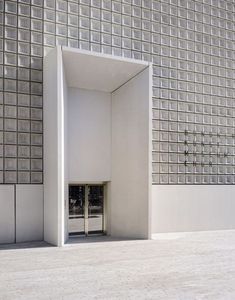 an open door in front of a building with glass blocks on the wall and floor