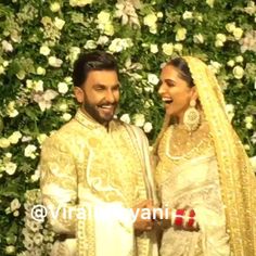 the newly married couple is posing in front of a floral wall at their wedding reception