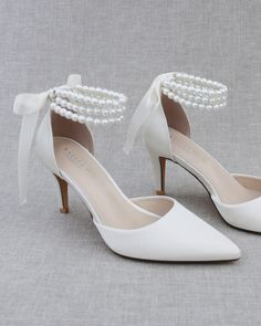 Classic satin pointy toe wedding heels with an added touch of elegance. Featuring our trinity pearl strap, which includes three rows of pearls around the ankle. Tie silky ribbon bow at the back for a secure fitting. Perfect for brides, bridal party, bridesmaids, prom, parties, or any special occasion. DETAILS: HEELS: 3 inches UPPER: Synthetic upper and lining MATERIALS: Manmade outsole ORIGIN: Imported Women Shoes Collection, Quinceanera Shoes, Wedding Shoes Sandals, White Bridal Shoes, Flower Girl Shoes, Bridal Wrap, Bridesmaid Shoes, Pearl Collection, Wedding Heels