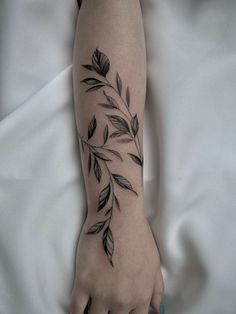 a woman's arm with leaves on it