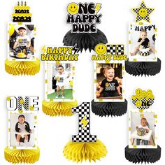 a number one birthday party decoration with yellow tissue pom poms and black and white decorations