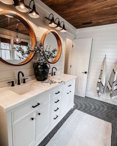 a bathroom with two sinks and mirrors in it