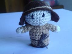 a small crocheted doll with a hat on it's head