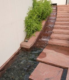 the steps lead up to an outdoor water feature that is flowing from one side into another