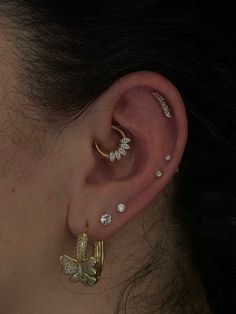 a close up of a person's ear with three different types of piercings