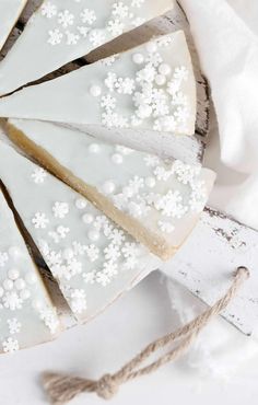 a cake with white frosting and flowers on it is sitting on a wooden board