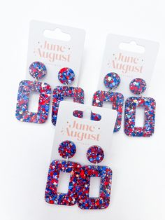 six pairs of earrings with red, white and blue glitters on them in front of a card