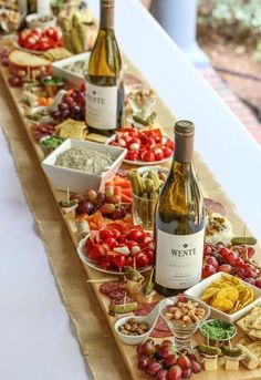 a long table filled with lots of food and bottles of wine on top of it