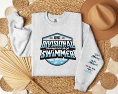 "Custom Sleeve Divisional Championship Swimming Sweatshirt Gift for Swimmer Custom Aquatics Club Sweatshirt Swim Team Personalized shirt   A custom swimming sleeve print sweatshirt is a stylish and comfortable way to celebrate accomplishments in the pool. Made from premium materials and available in a wide range of designs, these sweatshirts are perfect for competitive swimmers. Whether you're looking for a bold statement piece or simply want to start conversations with other swimming enthusiasts, a swimming-themed sweatshirt is an ideal choice. So, if you want to show off your passion for swimming in a fashionable and practical way, consider purchasing a custom swimming-inspired sweatshirt today. Steps for ordering: 1. Select your choice of Color 2. Select shirt size 3. Carefully enter th Swim Shirt Ideas, Crew Neck Top With Graphic Print For Water Sports, Graphic Print Crew Neck Top For Water Sports, Custom Logo Crew Neck Tops For Sports Season, Crew Neck Tops With Custom Logo For Sports Season, Swim Shirt Designs, Swim Team Shirts, Swim Team Gifts, Gifts For Swimmers