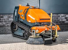 an orange and black machine sitting on top of a sidewalk