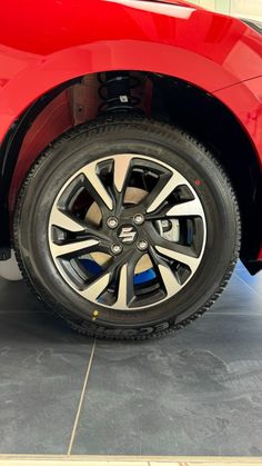 the front wheel of a red car in a showroom