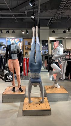 two mannequins are standing on wooden platforms