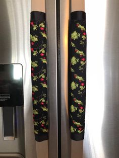 the door handles are decorated with holly and red berries on black fabric, as well as silver refrigerator doors