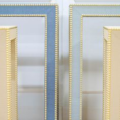 two blue and gold framed mirrors with beading on the edges, one is empty