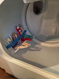 two dolls are sitting in the washing machine