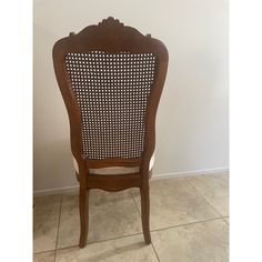 a wooden chair sitting on top of a tile floor