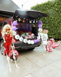 a car decorated for halloween with skeletons and balloons in the trunk, as well as decorations