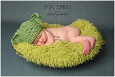 a newborn baby is wearing a green hat