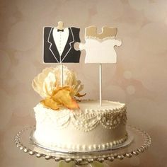 a wedding cake decorated with white frosting and two small wooden signs on top of it