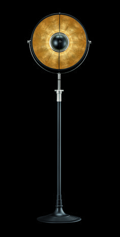 a black and gold floor lamp on a black background