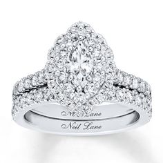 a white gold ring with two rows of diamonds on the band and an oval shaped center diamond