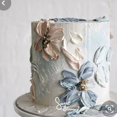 a white and blue cake with flowers on it