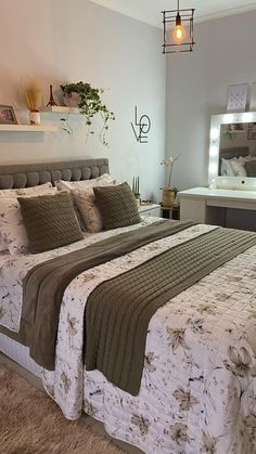 a bedroom with a large bed, mirror and lights on the wall above it's headboard