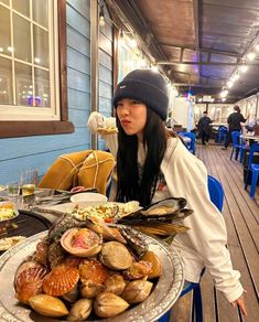 a woman sitting in front of a plate of food on top of a wooden table