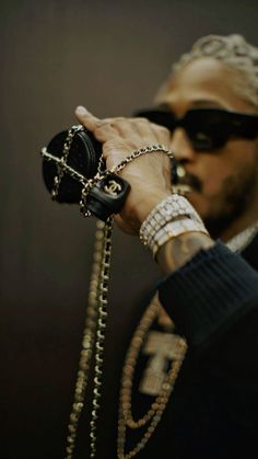 a man wearing sunglasses and holding onto some chains