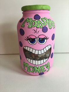 a pink jar with purple and green polka dots on it that says, monster money