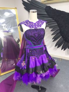 a purple and black dress on display in front of a mirror