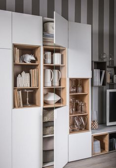 an open cabinet with dishes and cups in it