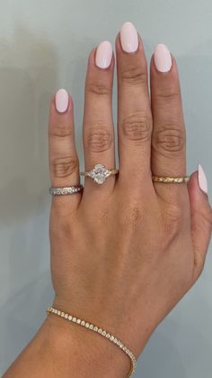 a woman's hand with two different rings on her left and the middle finger