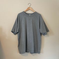 This Is A Heavy Fit T-Shirt. Never Worn! Gray Cotton T-shirt For Loungewear, Sporty Plain Short Sleeve T-shirt, Plain Cotton T-shirt For Loungewear, Gray Crew Neck T-shirt For Loungewear, Sporty Plain T-shirt With Relaxed Fit, Gray Oversized Short Sleeve Shirt, Oversized Gray Short Sleeve Shirt, Casual Gray T-shirt For Loungewear, Sporty Relaxed Fit Plain T-shirt