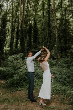 a man and woman dancing in the woods