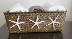 two white dogs laying in a basket with starfish decorations on the bottom and sides