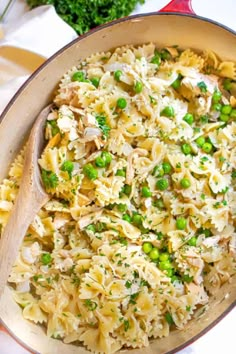 a pan filled with pasta and peas on top of a table