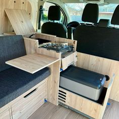 the interior of an rv with wood paneling and black seats, built into the floor