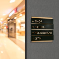 there are signs on the wall in this shopping mall that read shop sauna restaurant gym