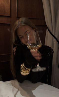 a woman holding a wine glass up to her face