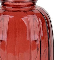 a red glass vase is shown on a white background