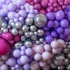 there are many different colored balls in the air and one is pink, purple, silver and white