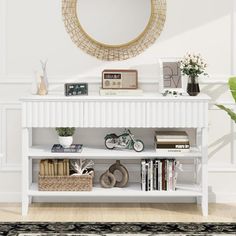 there is a white shelf with books on it and a mirror in the corner behind it