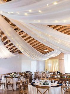 a room filled with lots of tables covered in white draping