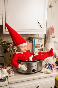 an elf is sitting in a pot on the kitchen counter