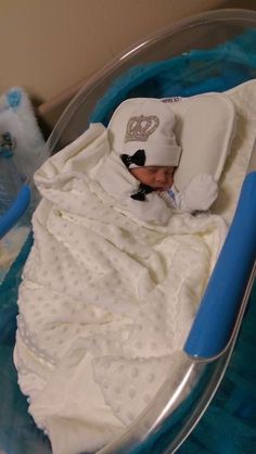 a baby in a crib with a hat and blanket