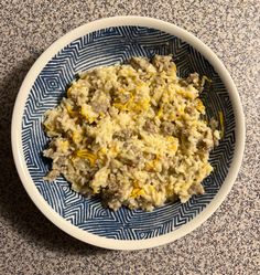 a blue and white bowl filled with food sitting on top of a granite countertop