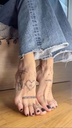 a woman's feet with tattoos on them